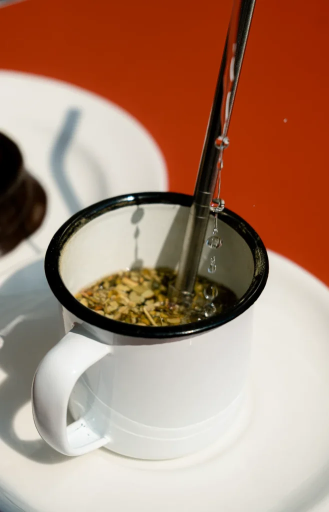 tasse de maté avec de l'eau chaude qui tombe à l'intérieur sur une table rouge photographie culinaire nantes pack photo mensuel ciao tutti studio