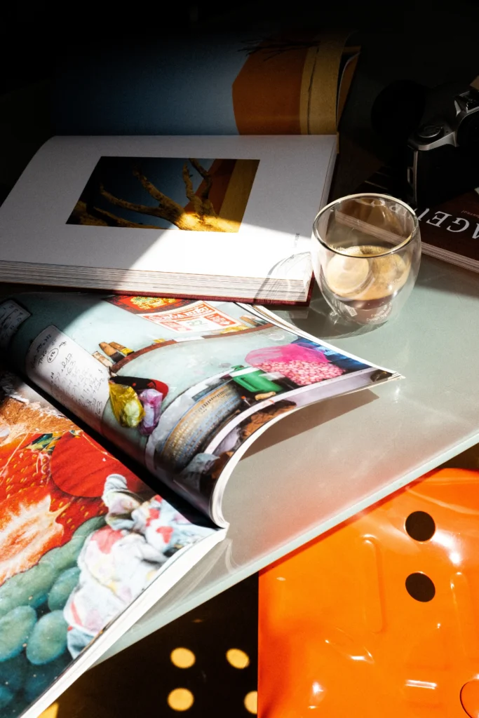 5 bonnes raisons de faire appel à un photographe événementiel cafe sur un bureau avec un livre photo ouvert chaise orange