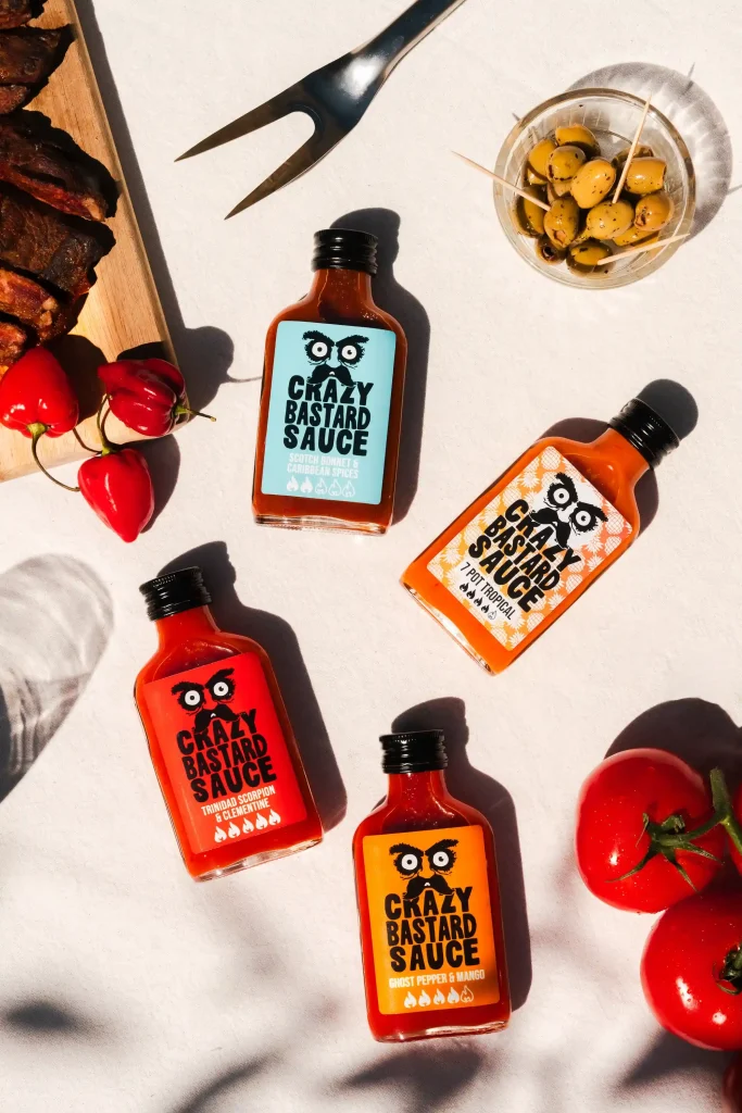 quatre sauces piquantes différentes posées sur une table de barbecue en extérieur été soleil photographie culinaire ciao tutti studio nantes