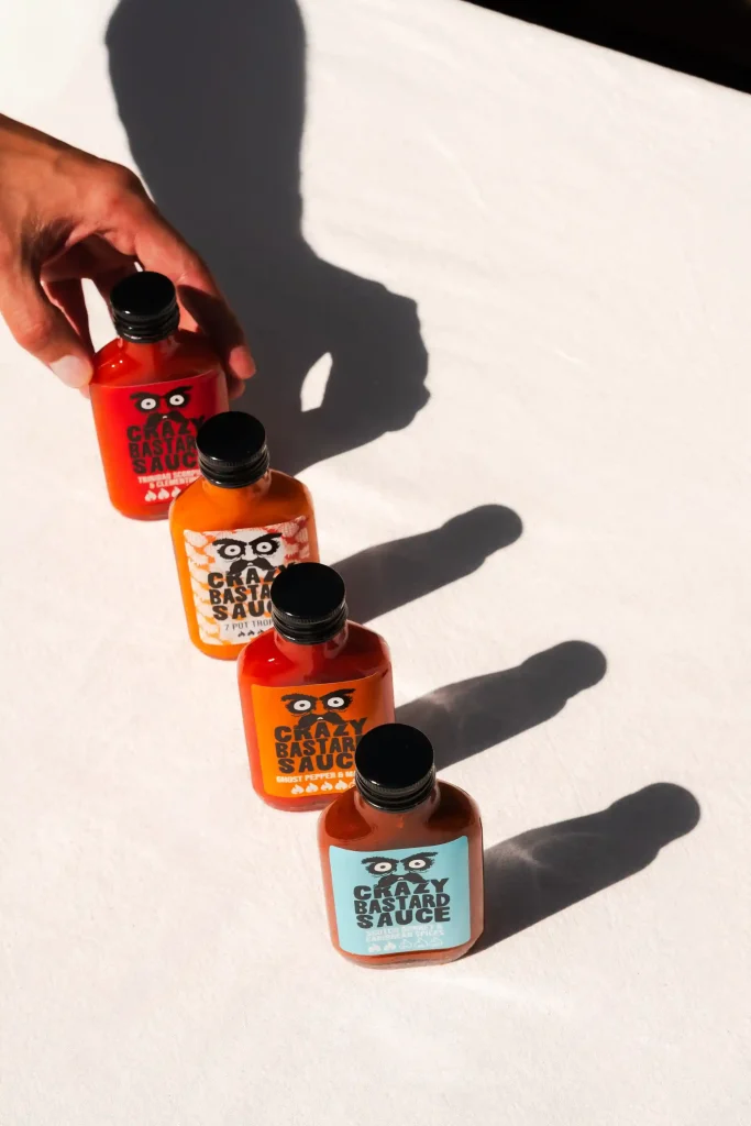 ombres sauces piquantes quatre produits crazy bastard sauce table blanche apéritif photographie culinaire ciao tutti studio nantes
